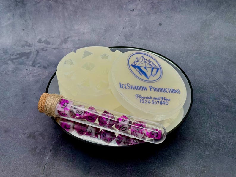 Custom silicone dice mold and matching lid beside purple dice in a corked glass tube