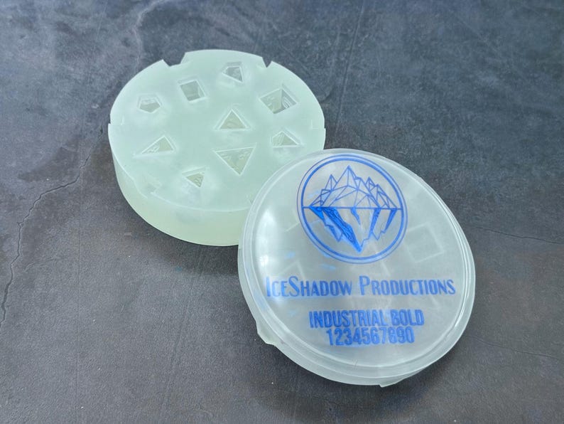 Numbered silicone dice mold with nine polyhedral cavities and a matching blue-lettered lid