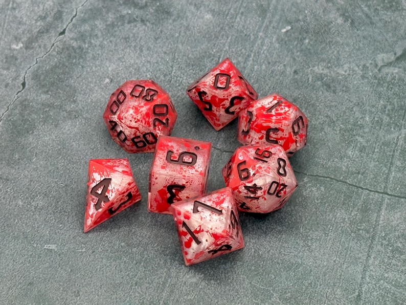 Slaughter resin dice with red splatter patterns and dark numbers